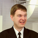 Alfred 'Gnorkmork' Lingerschreib ist ein Mann im Anzug und schiefem Lächeln im Keller